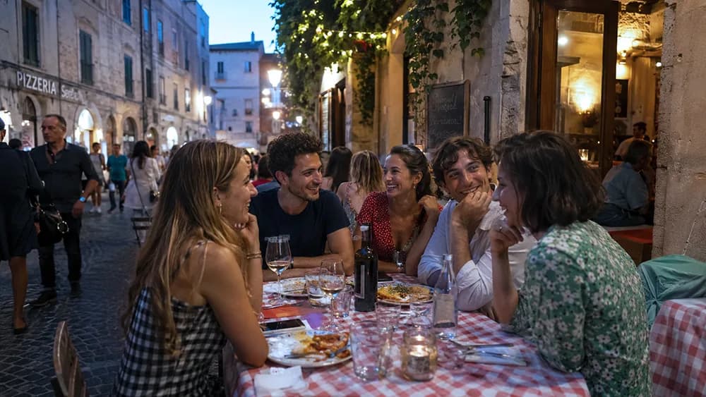 Amici a cena all'aperto in una trattoria durante una serata di vacanza